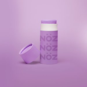 Frontal view of purple NOZ sunscreen. The cap is off, showing the bright color.